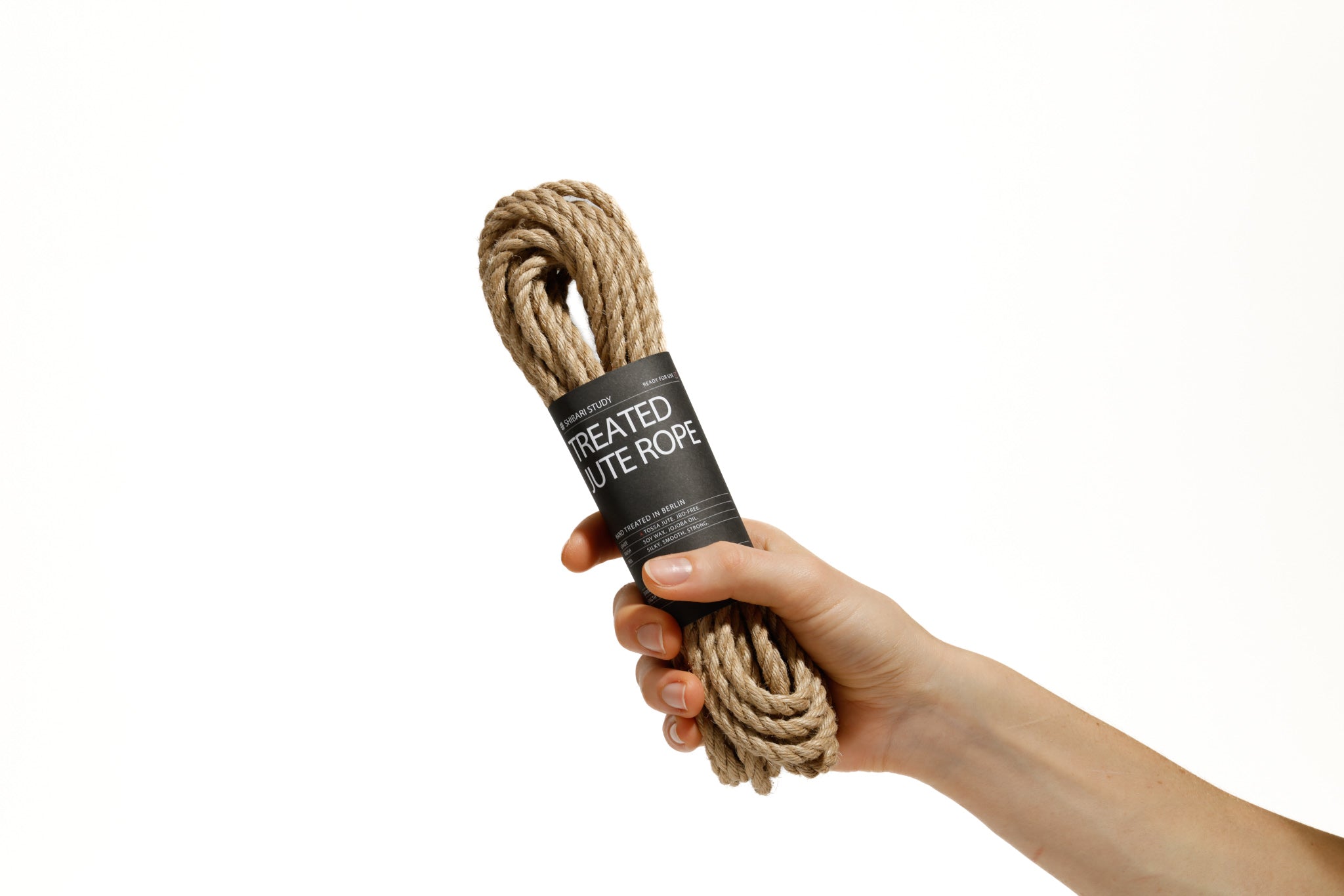 Hand holding treated jute rope with a label on a white background