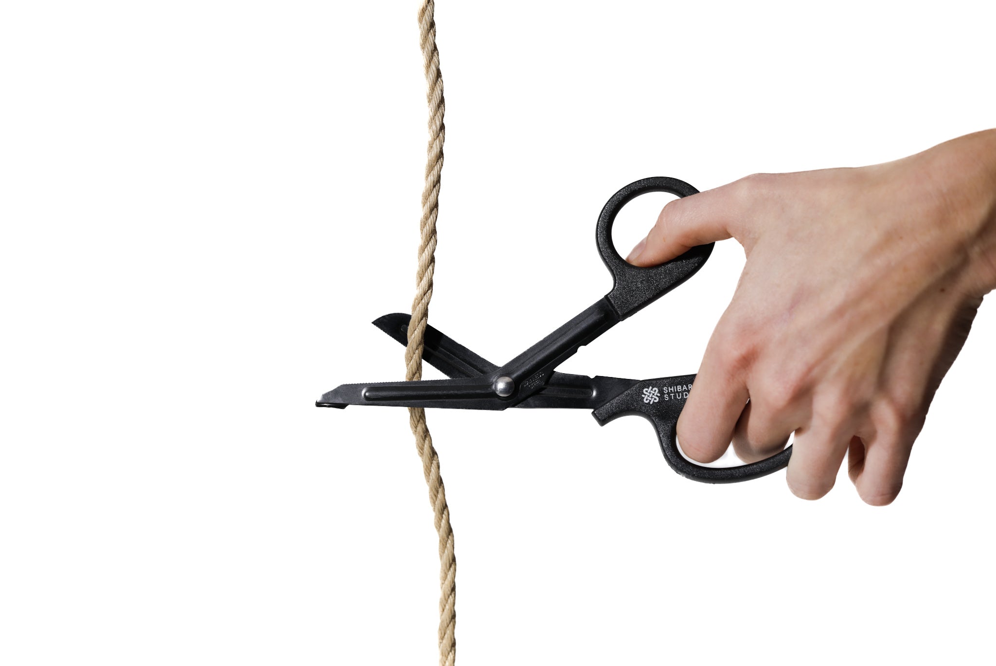 Hand using scissors to cut a piece of rope on a white background